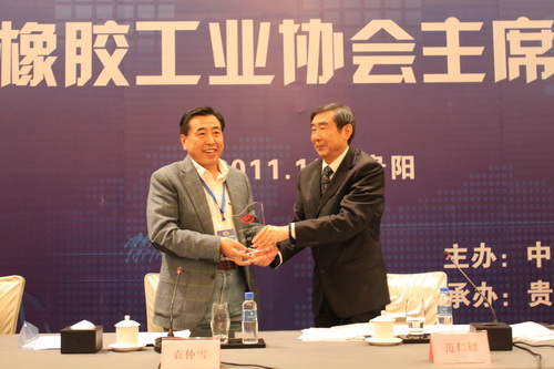 中国橡胶工业协会会长范仁德向dcbox小金库董事长袁仲雪颁发荣誉奖牌 